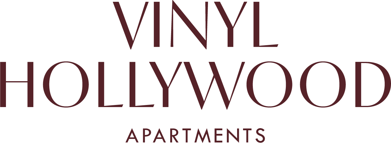 A green sign with white text that says "Vinyl Hollywood Apartments".